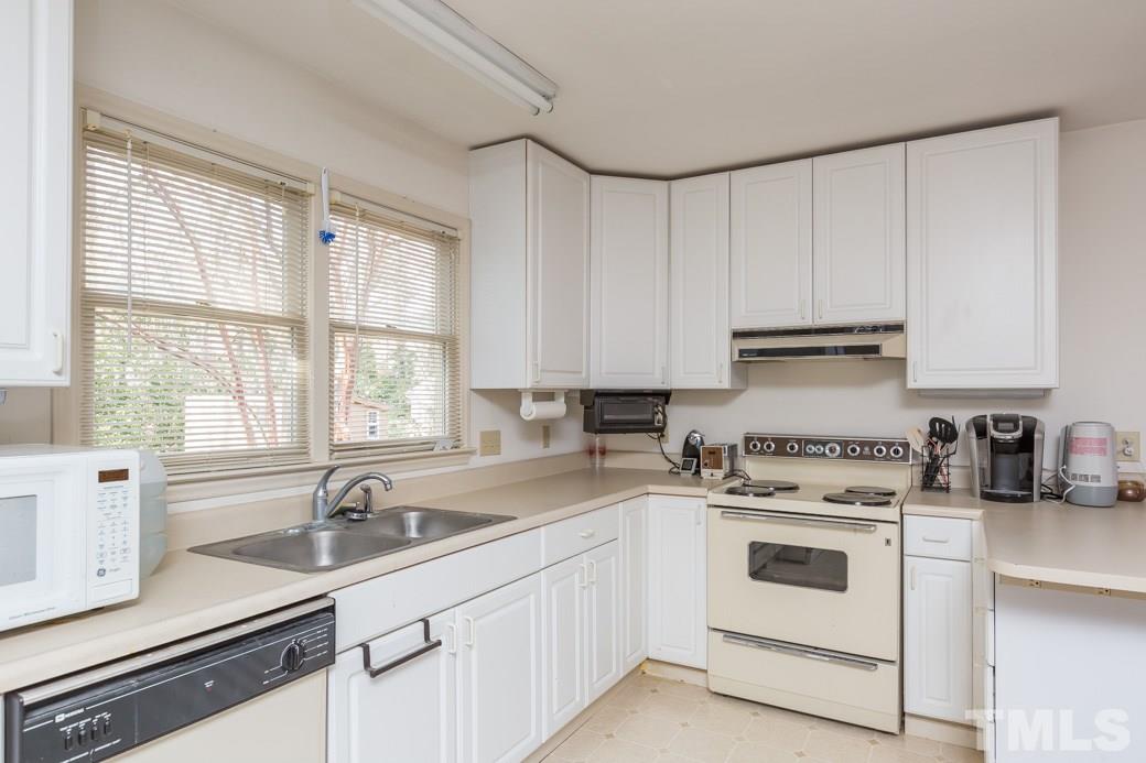 8632 Langtree Lane Raleigh, NC 27613 - Photo 16 of 25 a kitchen with cabinets appliances a sink and a window