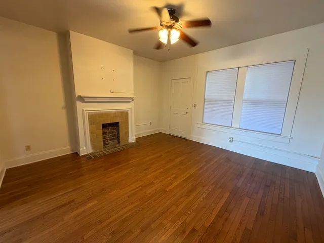 a view of empty room with wooden floor and fireplace
