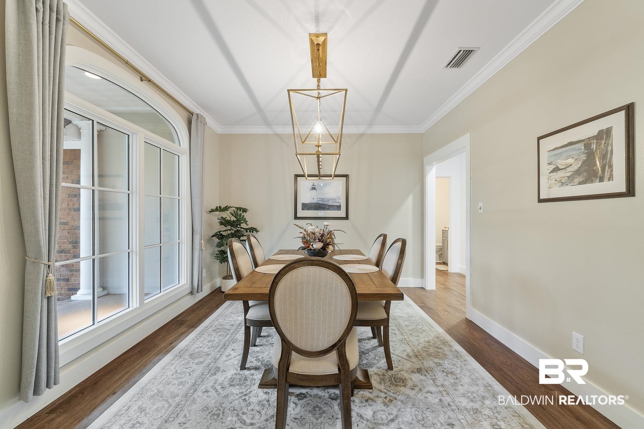 4451 Millhouse Road Gulf Shores, AL 36542 - Photo 14 of 50 Dining area with crown molding and dark wood-type flooring