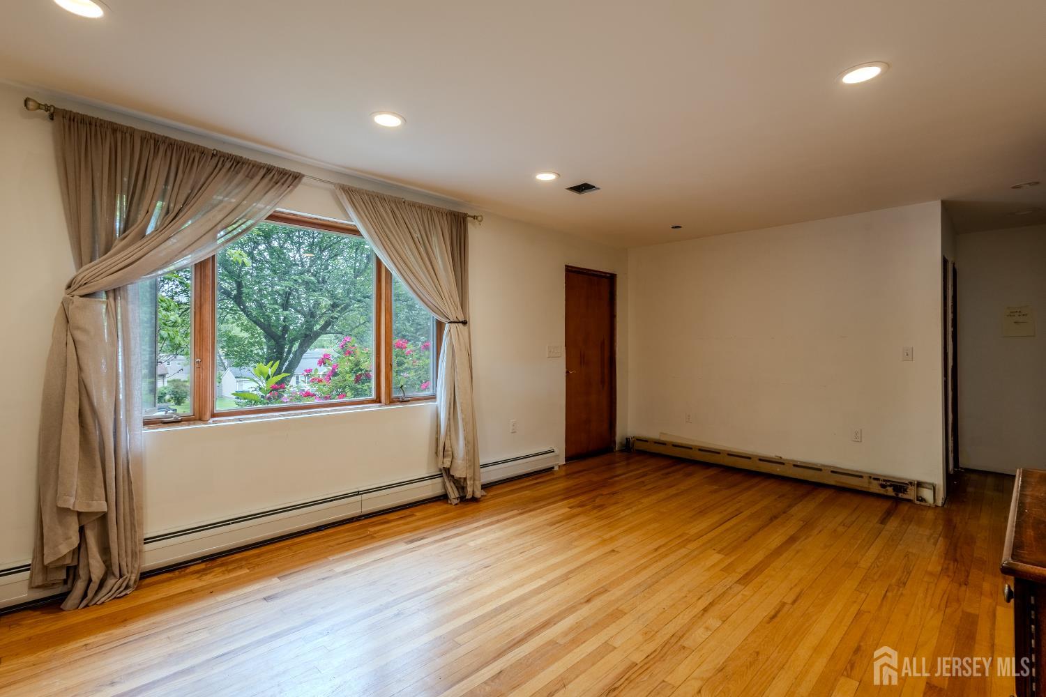 170 Jordan Road Colonia, NJ 07067 - Photo 4 of 36 a view of an empty room with wooden floor and a window