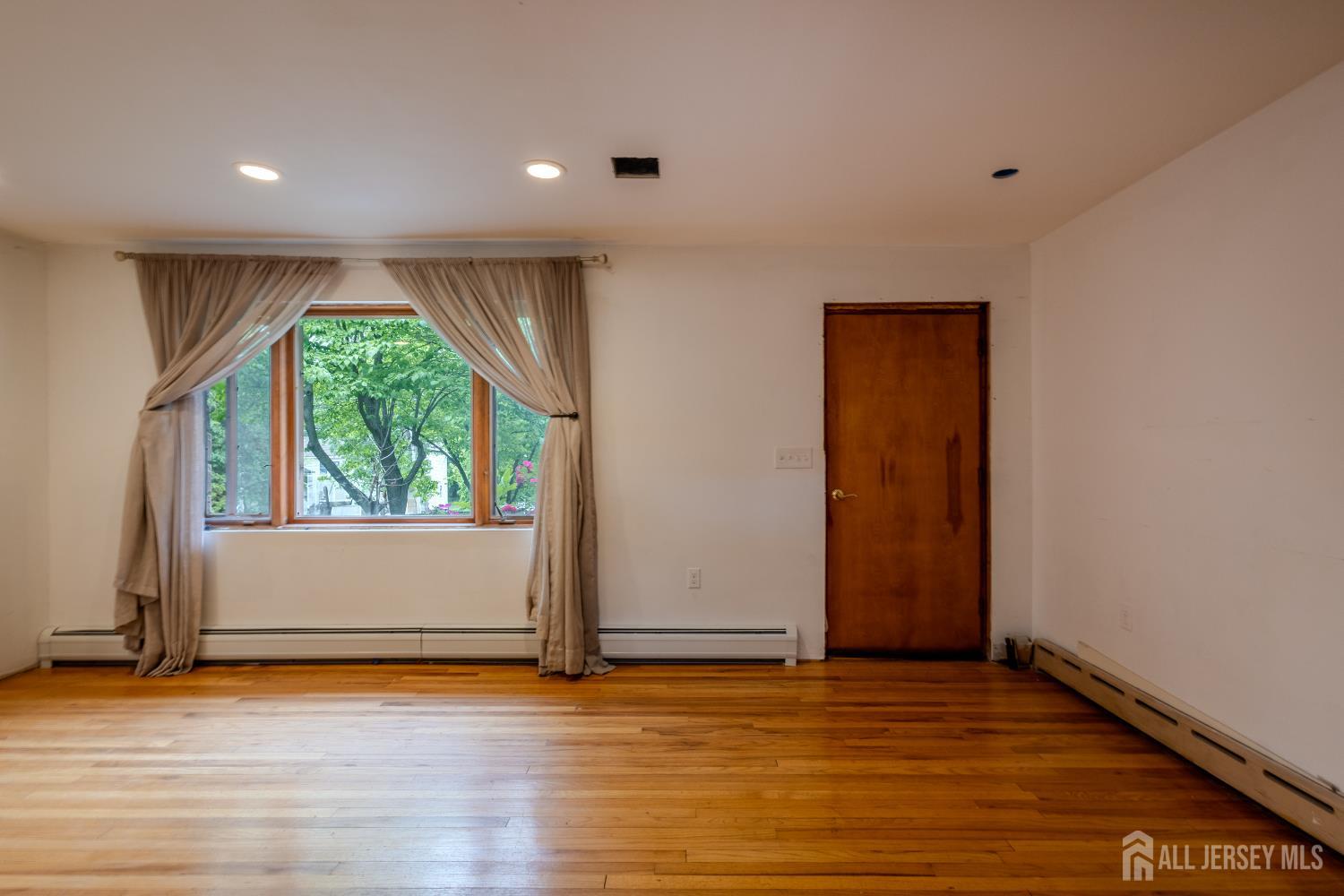 170 Jordan Road Colonia, NJ 07067 - Photo 6 of 36 an empty room with wooden floor and windows