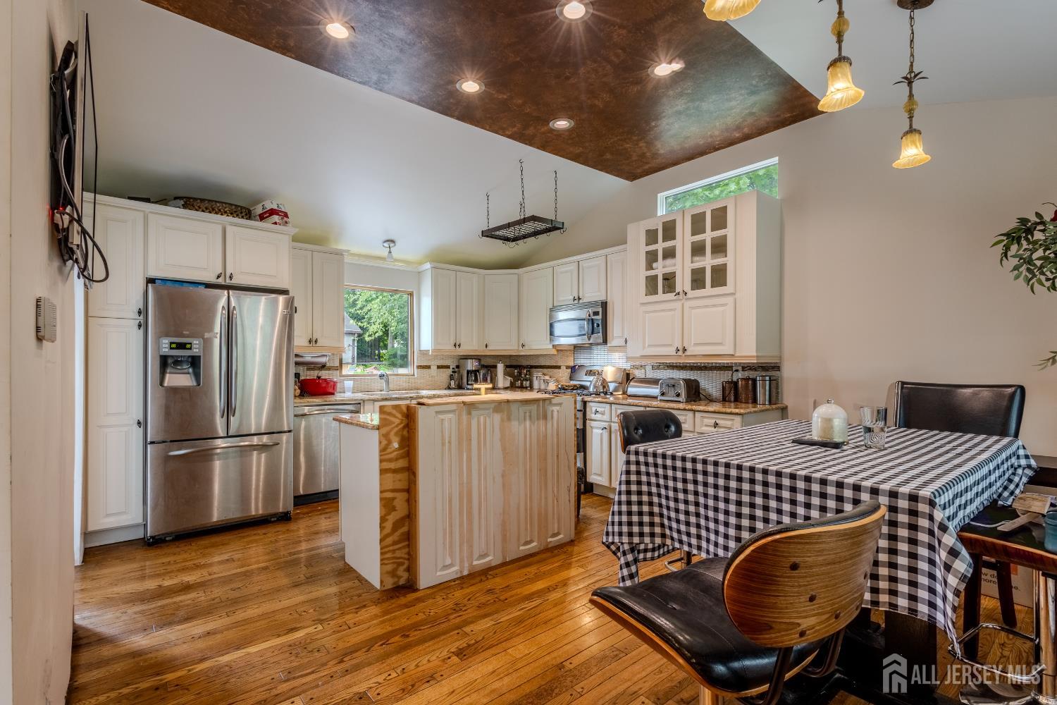 170 Jordan Road Colonia, NJ 07067 - Photo 8 of 36 a kitchen with stainless steel appliances granite countertop a refrigerator a sink dishwasher a dining table and chairs with wooden floor