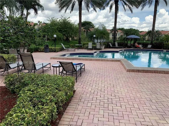 a swimming pool with outdoor seating and garden