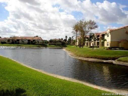 1235 Southwest 46th Avenue, Unit 711 Pompano Beach, FL 33069 - Photo 22 of 43 a view of a lake with houses in the back