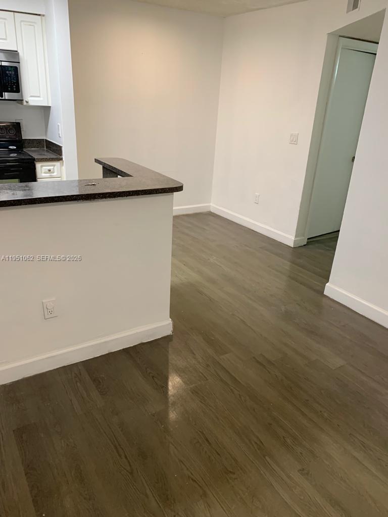 1235 Southwest 46th Avenue, Unit 711 Pompano Beach, FL 33069 - Photo 24 of 43 a view of a kitchen with wooden floor and a sink
