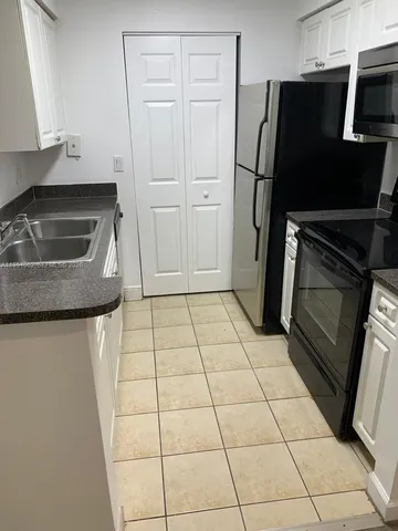 a kitchen with a refrigerator a stove