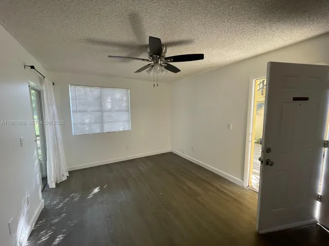 an empty room with windows and fan