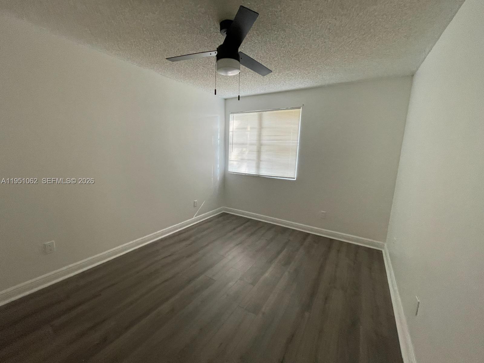 1235 Southwest 46th Avenue, Unit 711 Pompano Beach, FL 33069 - Photo 32 of 43 an empty room with wooden floor and windows