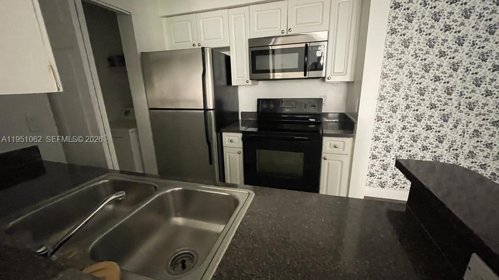 1235 Southwest 46th Avenue, Unit 711 Pompano Beach, FL 33069 - Photo 38 of 43 a kitchen with a refrigerator sink and microwave