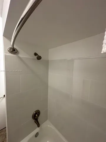 a bathroom with a white bath tub and a shower