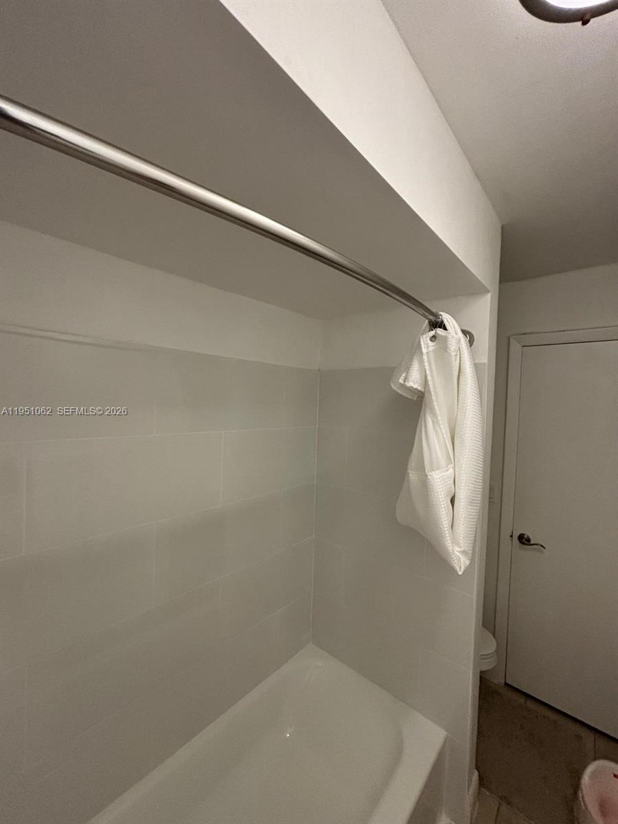 1235 Southwest 46th Avenue, Unit 711 Pompano Beach, FL 33069 - Photo 42 of 43 a bathroom with a white bath tub and a shower