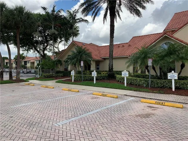 a view of a swimming pool with a yard and palm trees