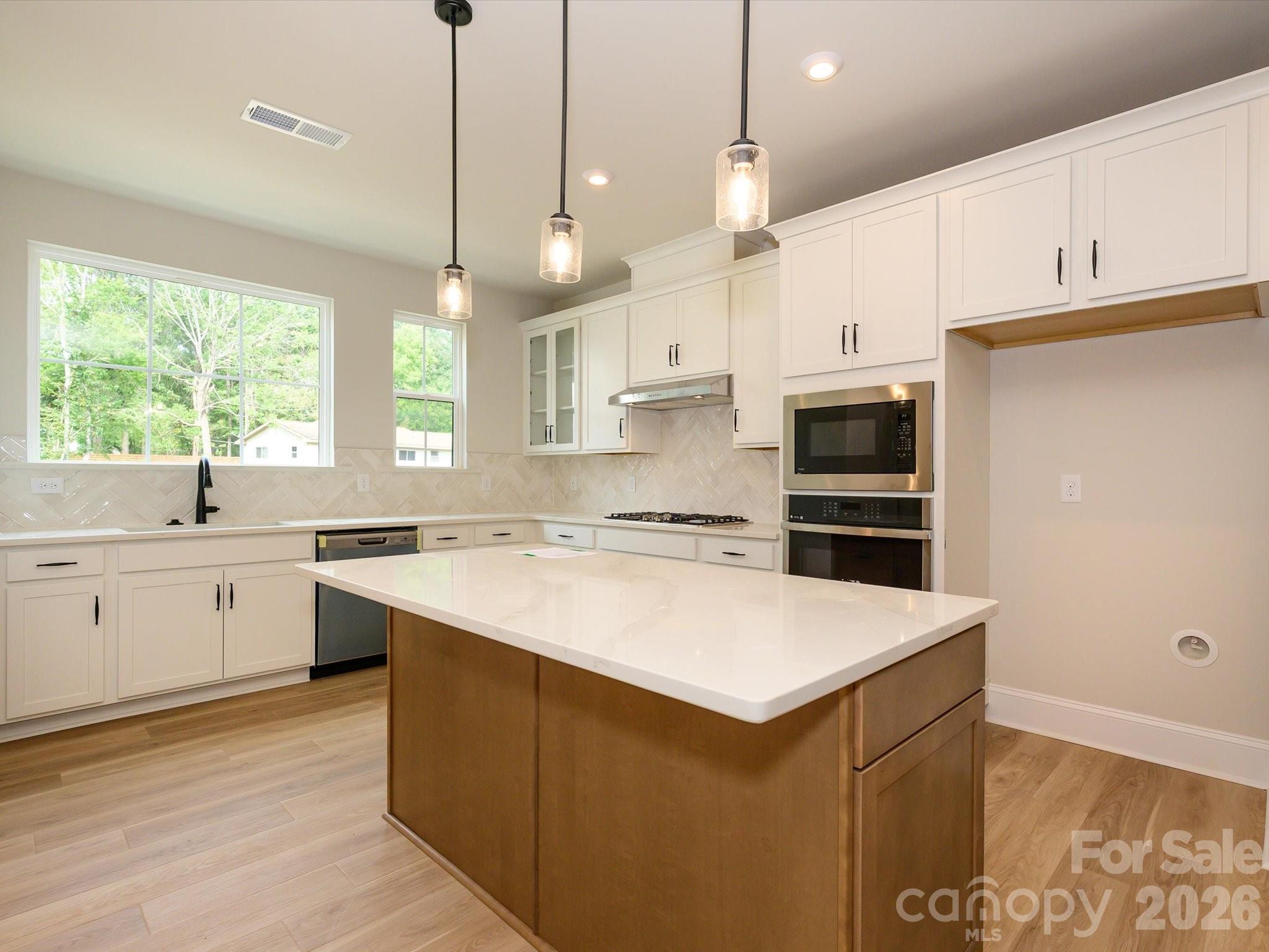 412 Old Town Vlg Road Waxhaw, NC 28173 - Photo 14 of 29 a kitchen with a sink a stove a refrigerator and white cabinets