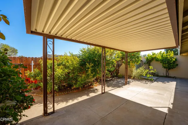 a patio with a table and chairs and potted plants