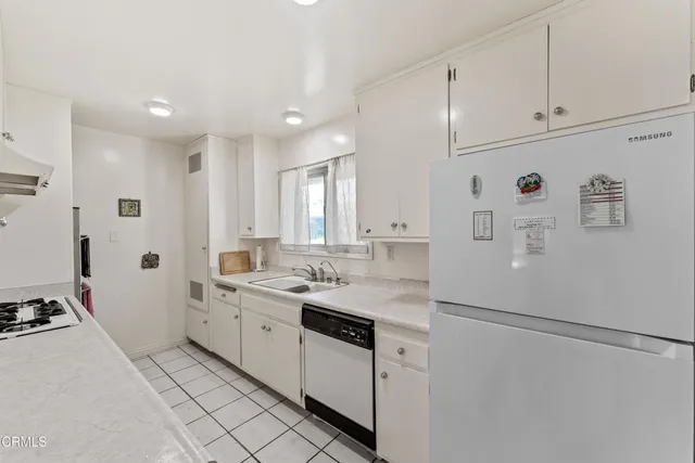 a kitchen with white cabinets and white appliances