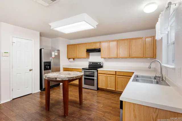 a kitchen with stainless steel appliances granite countertop wooden cabinets stove top oven and sink