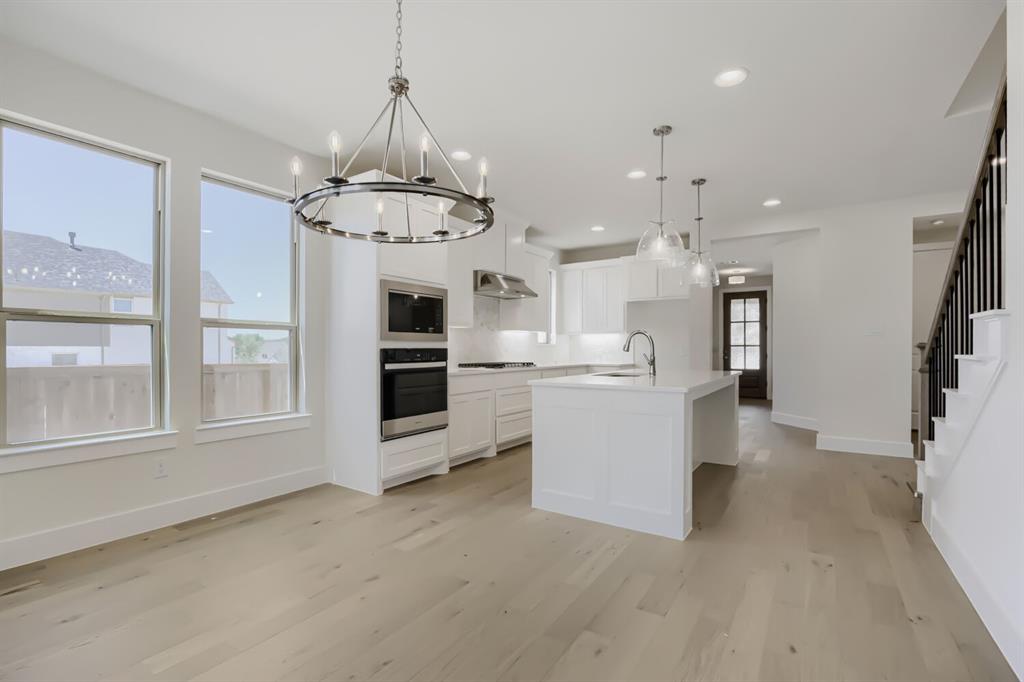 828 Stone Grv Road Lavon, TX 75166 - Photo 7 of 27 Open-concept living area featuring light wood-finish flooring and a contemporary chandelier