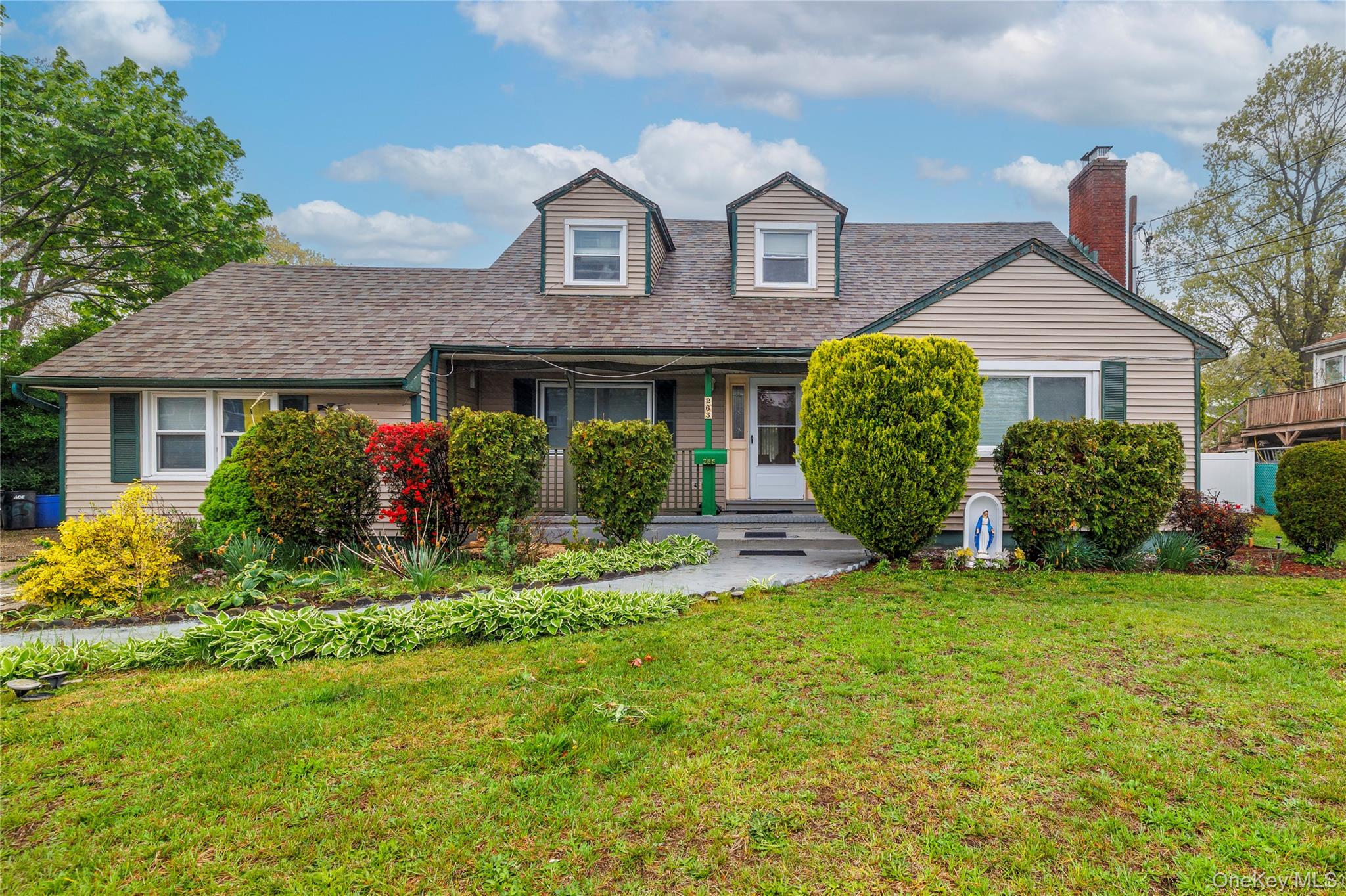 a front view of a house with a garden and plants