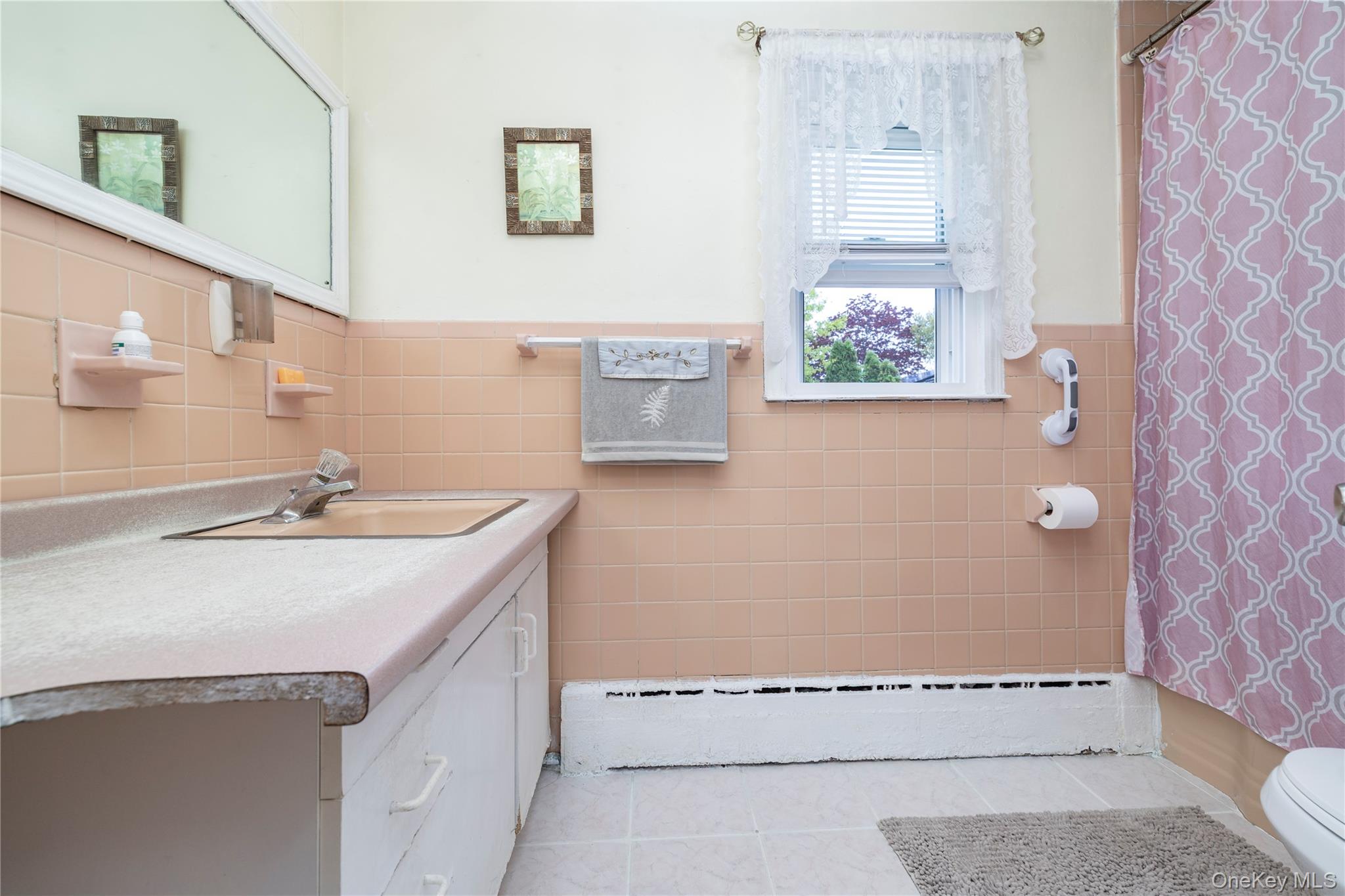 265 Beachview Street Copiague, NY 11726 - Photo 15 of 19 a bathroom with a sink a mirror and a bathtub