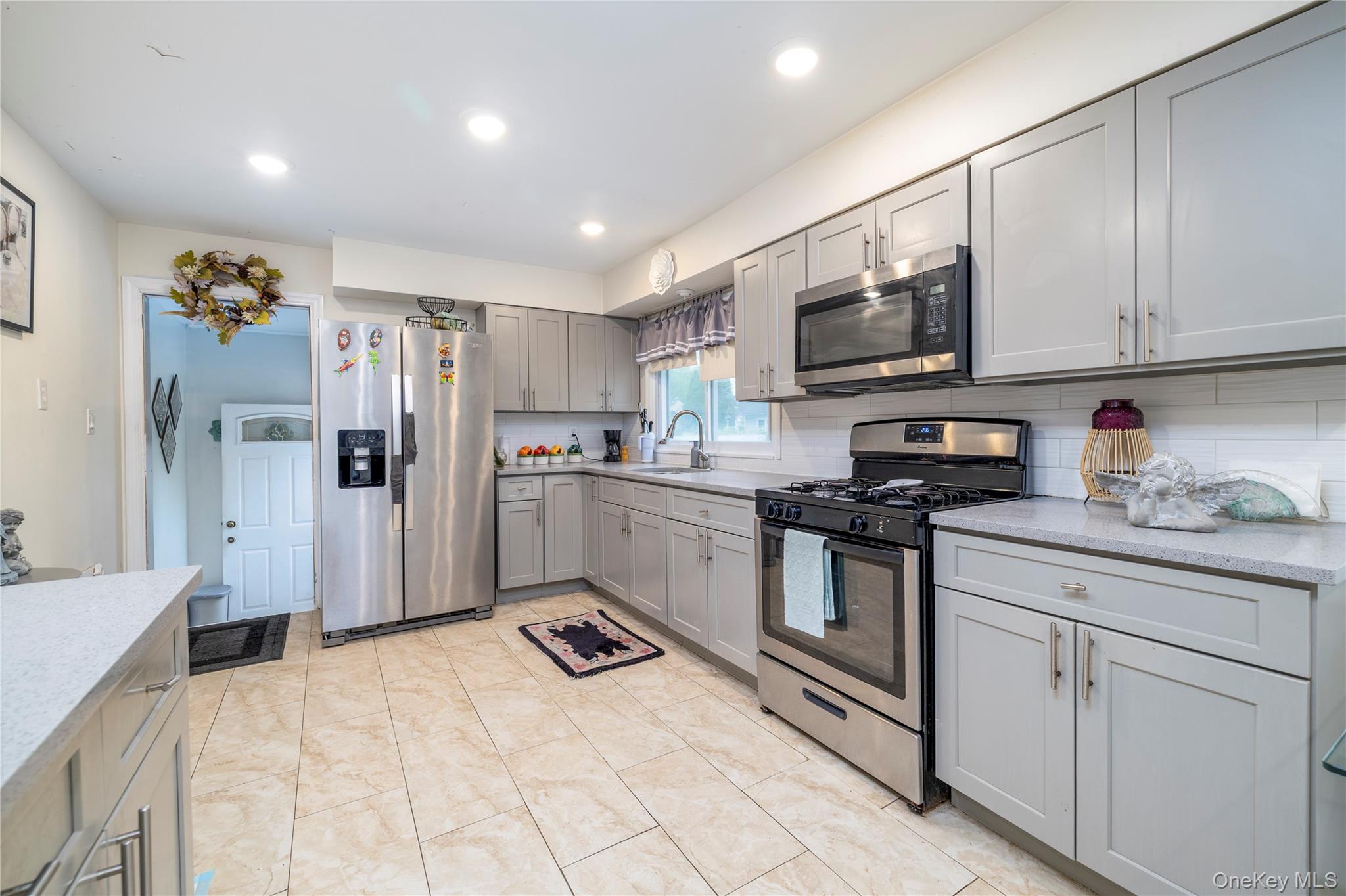 265 Beachview Street Copiague, NY 11726 - Photo 5 of 19 a kitchen with stainless steel appliances granite countertop a refrigerator sink and microwave
