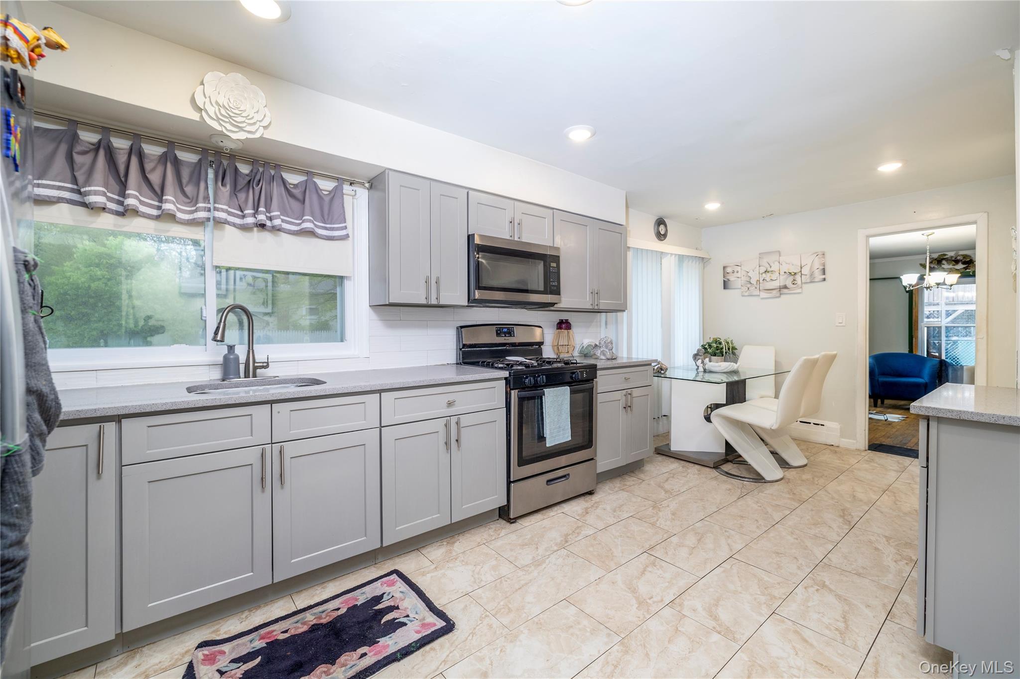 265 Beachview Street Copiague, NY 11726 - Photo 7 of 19 a open kitchen with stainless steel appliances kitchen island granite countertop a sink and cabinets