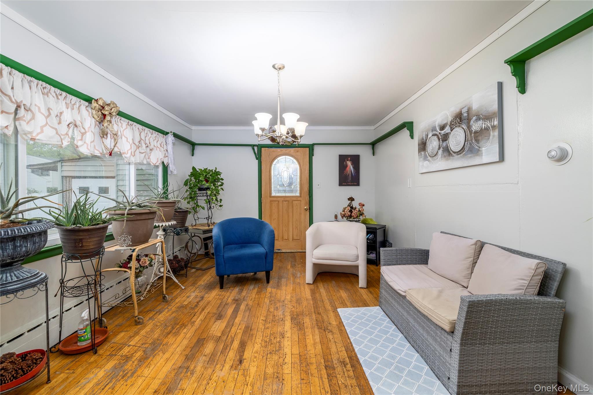 265 Beachview Street Copiague, NY 11726 - Photo 8 of 19 a living room with furniture and a chandelier