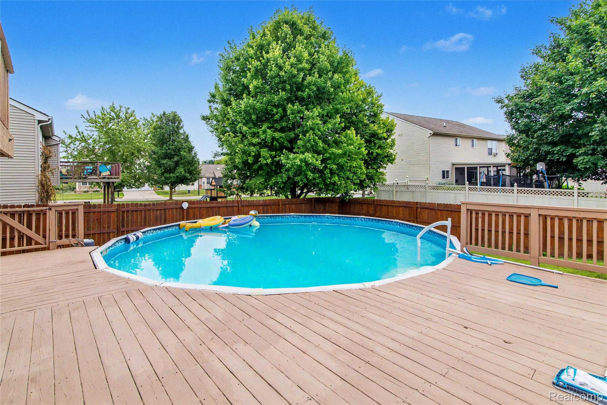 486 Sweet Briar Ridge Linden, MI 48451 - Photo 14 of 69 Expansive wood-finish deck with an integrated above-ground pool, surrounded by a wood fence