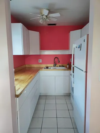 a view of a kitchen with a sink and refrigerator