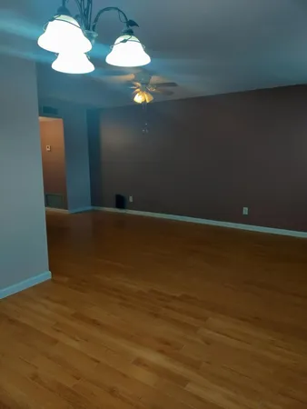 a view of a room with a ceiling fan and window