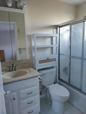 a bathroom with a sink toilet vanity and shower