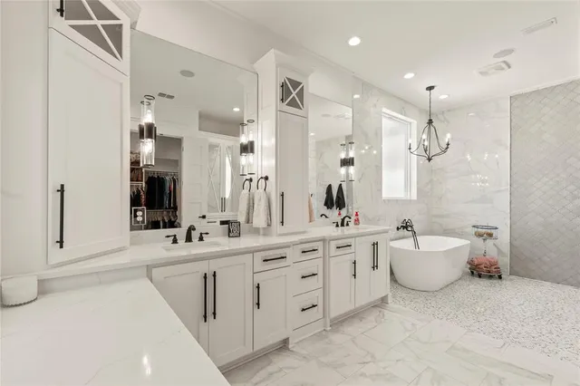 a bathroom with a double vanity sink mirror and bathtub
