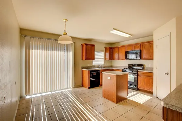a kitchen with stainless steel appliances granite countertop a stove top oven a sink dishwasher and a refrigerator with wooden floor