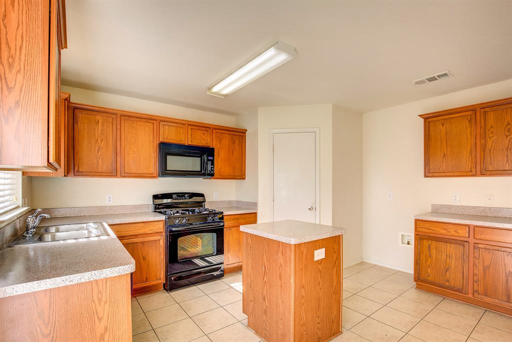 1720 Desperado Road Fort Worth, TX 76131 - Photo 14 of 40 a kitchen with stainless steel appliances granite countertop a sink stove and refrigerator