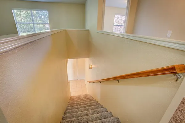 a view of a hallway with wooden floor and staircase