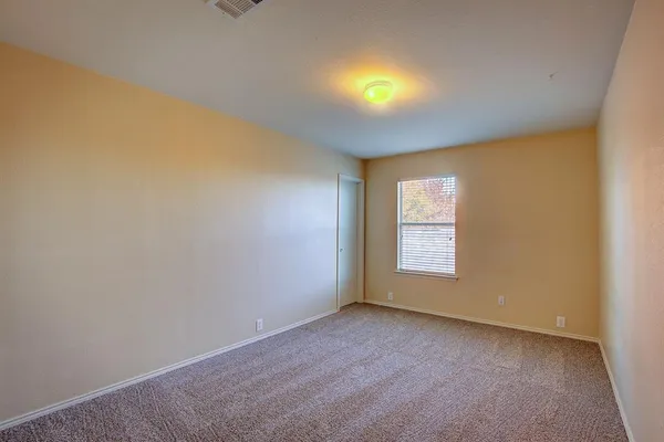 a view of an empty room with a window and fire place