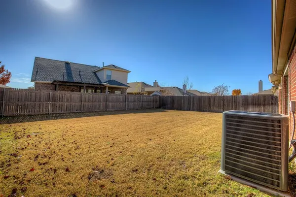 a view of a yard with wooden fence