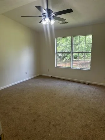 an empty room with a window and a fan