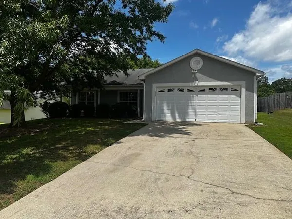 a front view of a house with yard and trees