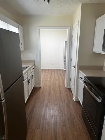 a kitchen with wooden floors and appliances