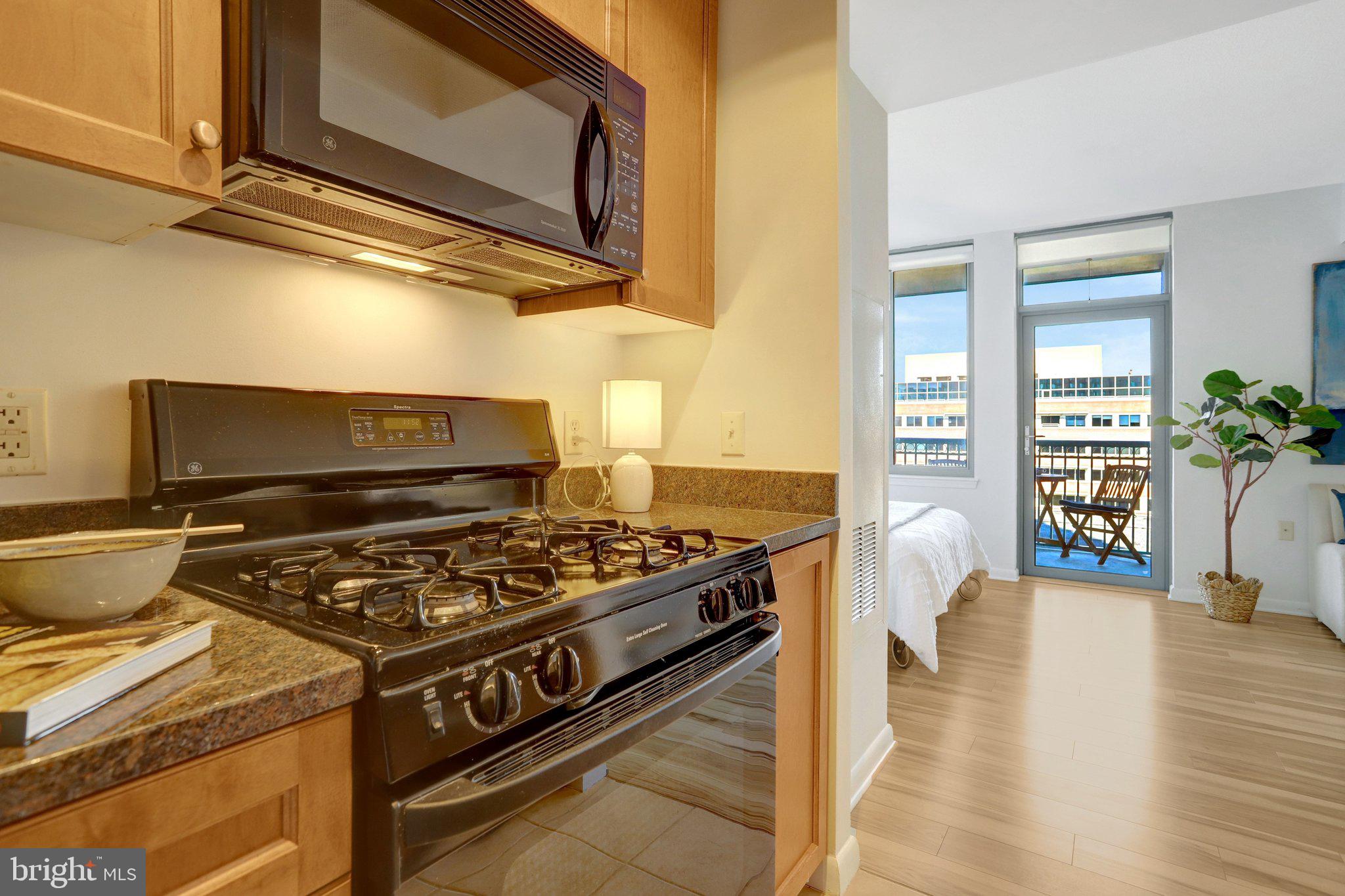 851 North Glebe Road, Unit 812 Arlington, VA 22203 - Photo 12 of 38 a kitchen with stainless steel appliances granite countertop a stove and a microwave