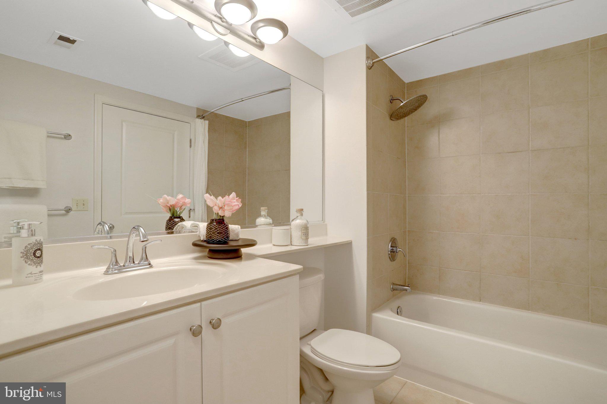 851 North Glebe Road, Unit 812 Arlington, VA 22203 - Photo 17 of 38 a bathroom with a sink a toilet a mirror a bathtub and shower