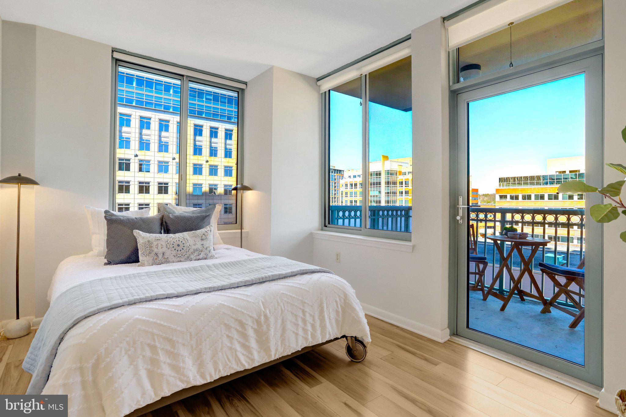 851 North Glebe Road, Unit 812 Arlington, VA 22203 - Photo 8 of 38 a bedroom with a bed and a table next to a window