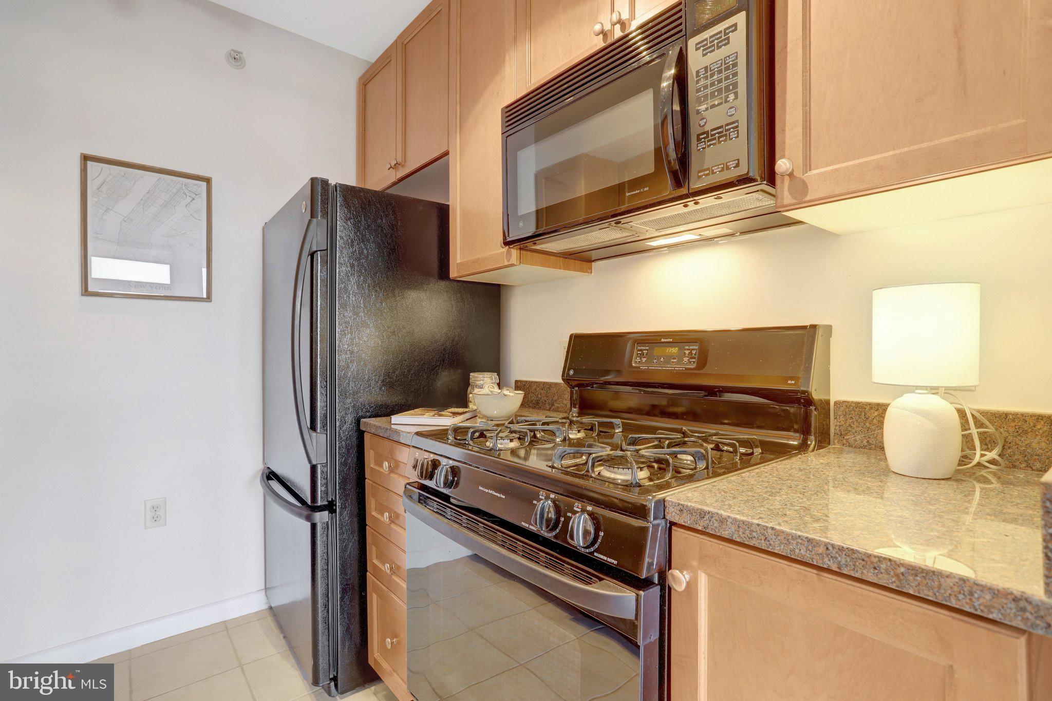 851 North Glebe Road, Unit 812 Arlington, VA 22203 - Photo 9 of 38 a kitchen with stainless steel appliances granite countertop a stove and a microwave