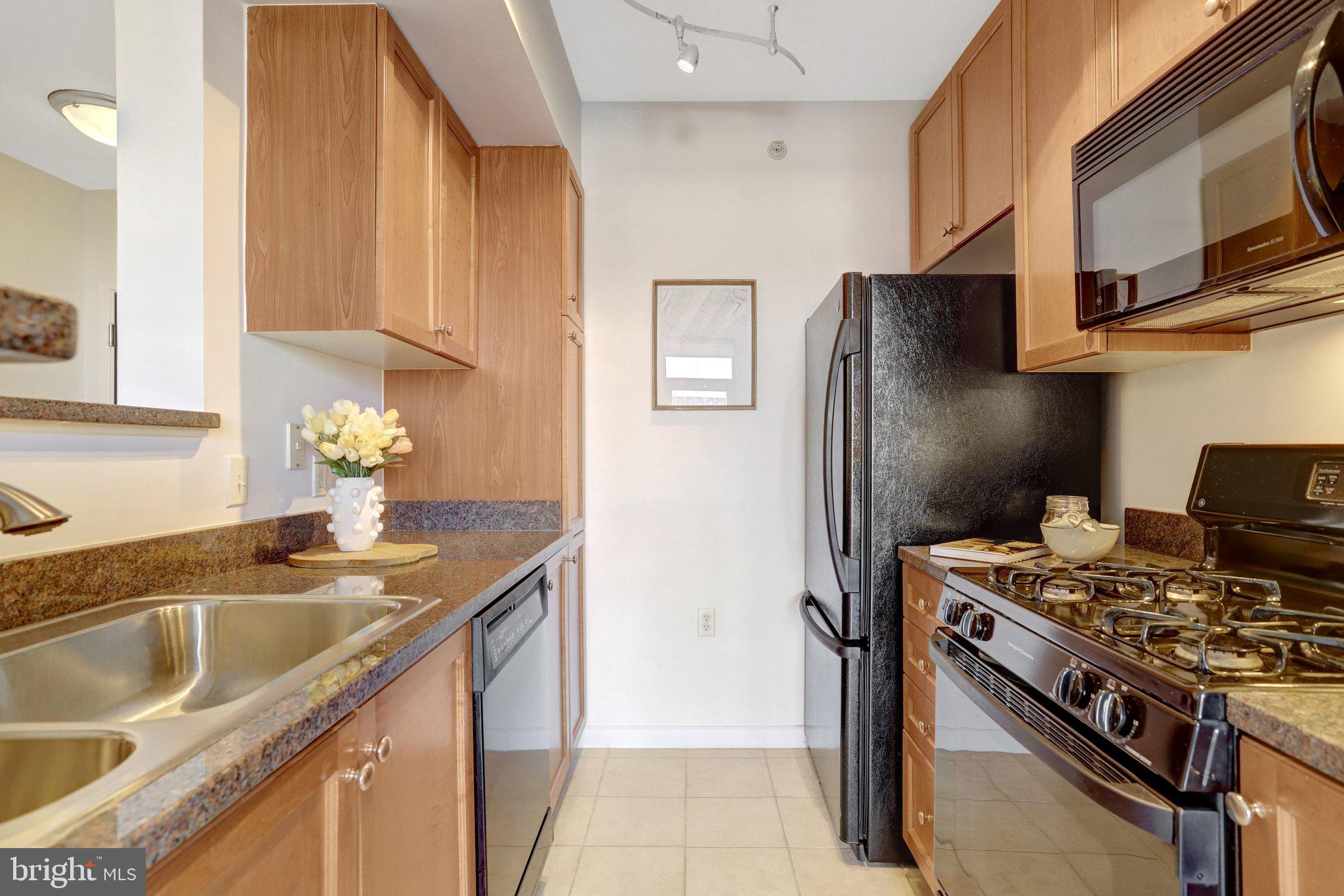851 North Glebe Road, Unit 812 Arlington, VA 22203 - Photo 10 of 38 a kitchen with stainless steel appliances granite countertop a sink stove and refrigerator