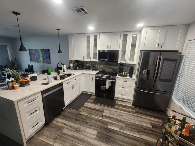 a kitchen with a sink a stove a refrigerator and cabinets