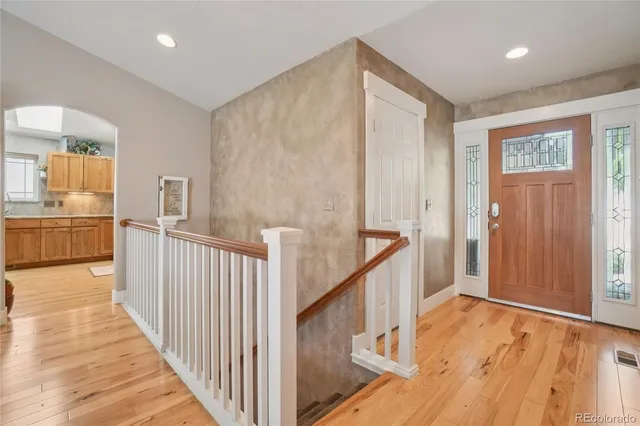 a view of a hallway with wooden floor and staircase