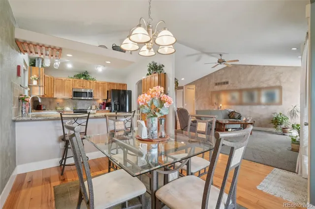 a view of a dining room with furniture a chandelier and wooden floor
