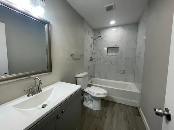 a bathroom with a double vanity sink toilet a mirror and shower