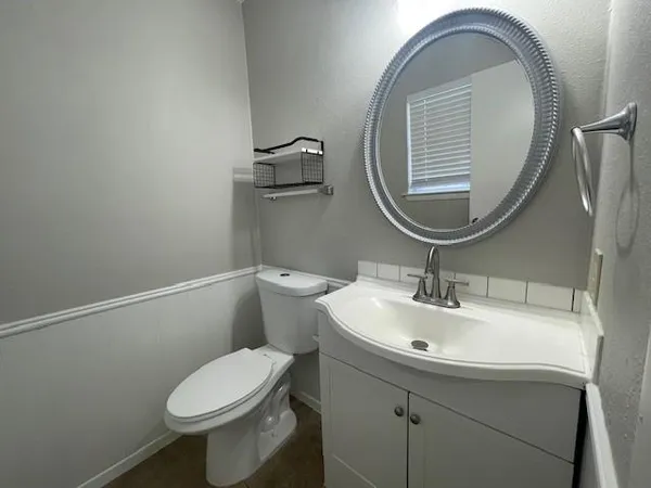 a bathroom with a toilet sink and mirror