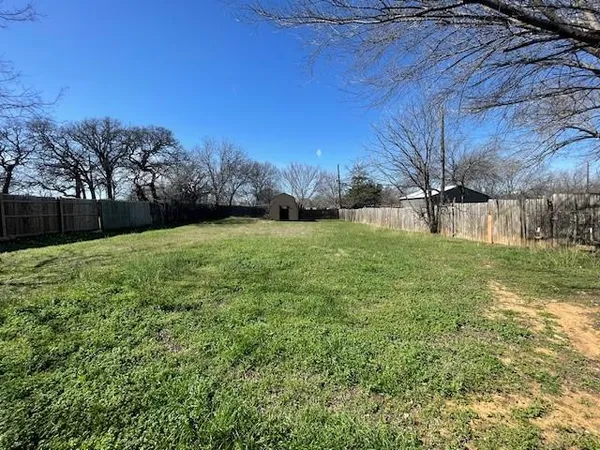 a view of a backyard with large trees